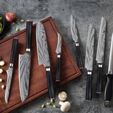 Home & Beyond Co Damascus steel chef's knife set with multiple kitchen knives displayed on a cutting board.